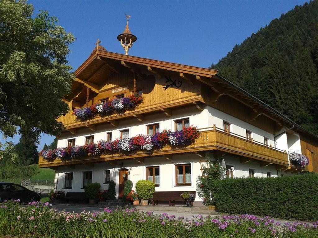a building with flowers on the side of it at Bauernhof Strasserhof in Söll