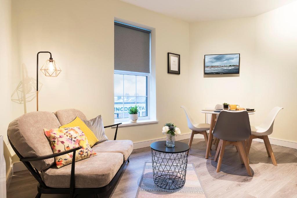 uma sala de estar com um sofá e uma mesa em Blue Door Apartments em Newcastle