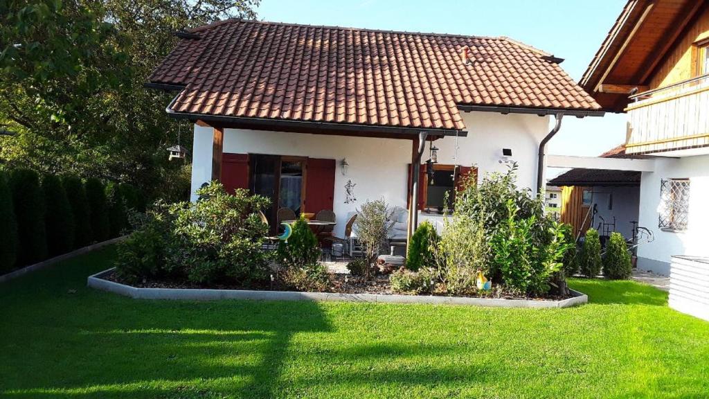 a small white house with a grass yard at Haus Schloßwiese in Bad Füssing