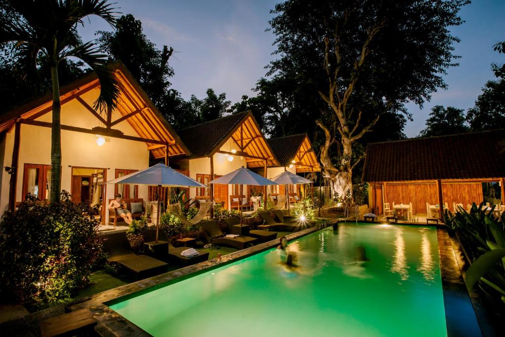 uma casa com piscina à noite em Nuansa Penida Hostel em Nusa Penida