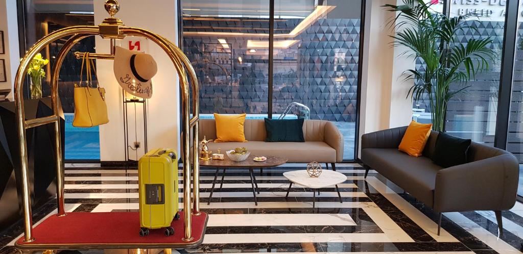 Swiss-Belboutique Bneid Al Gar Kuwait في الكويت: غرفة معيشة مع حقيبة صفراء وأريكة