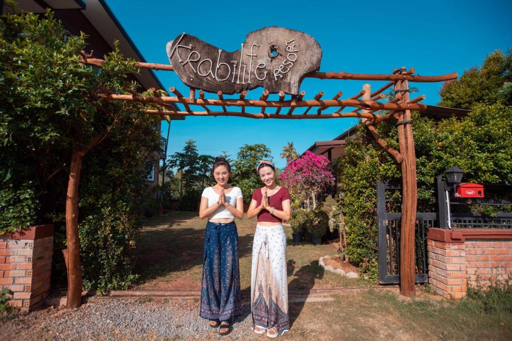 deux femmes debout sous une pancarte dans un zoo dans l'établissement Krabilife Resort, à Klong Muang Beach