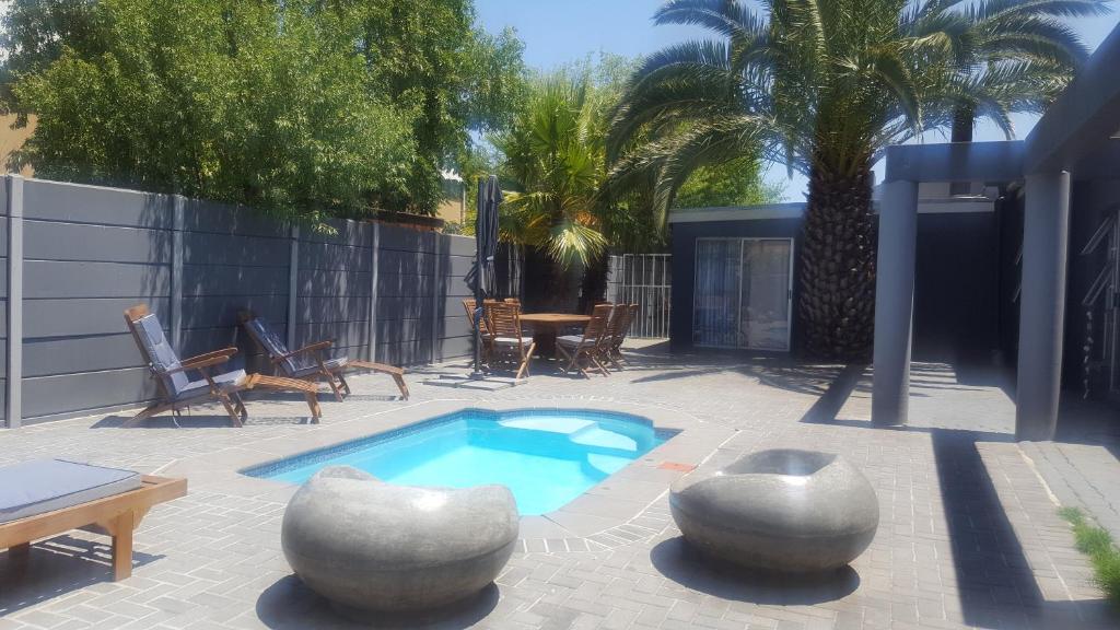 un patio con piscina, mesa y sillas en Hayley's Place en Ciudad del Cabo