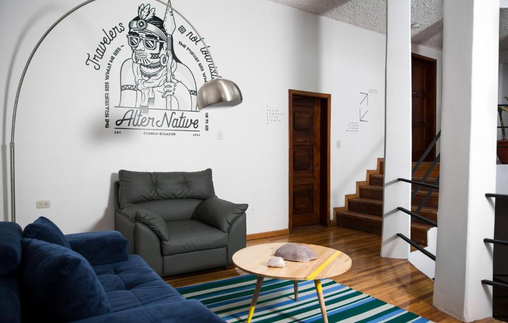 a living room with a blue couch and a table at AlterNative Hostels in Cuenca