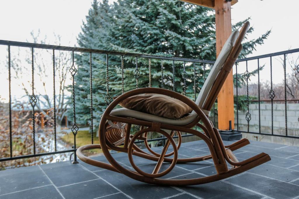 a wooden rocking chair sitting on a porch at In Gyumri in Gyumri