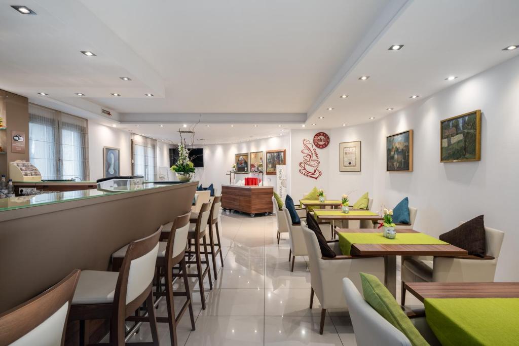 a restaurant with tables and chairs and a bar at Bükkös Hotel & Spa in Szentendre