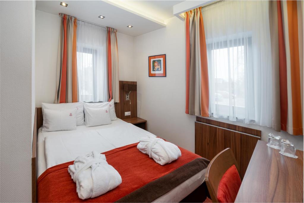 a bedroom with a bed with towels on it at Bükkös Hotel & Spa in Szentendre