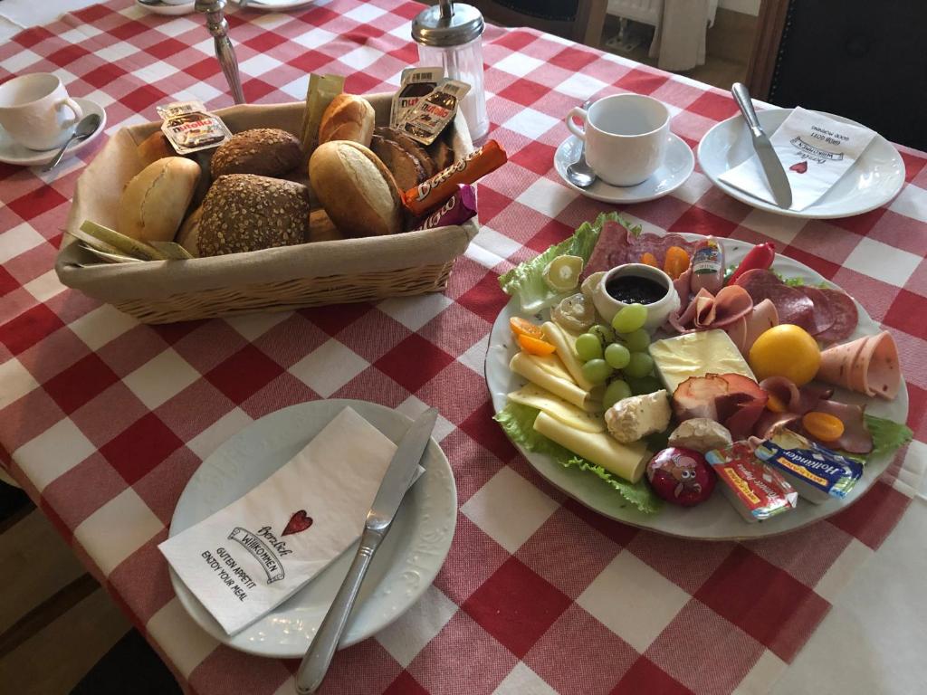 a table with a basket of bread and a plate of food at Landlust Hotel in Gransee