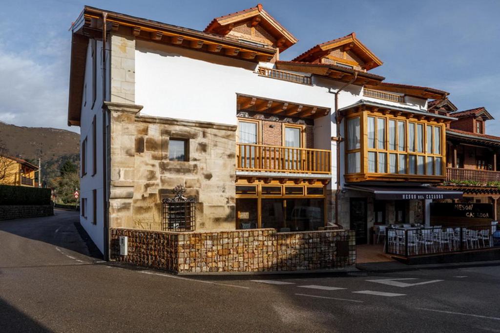 a building with a balcony on the side of a street at Posada rural Fuente Juliana in Barrio de Arriba