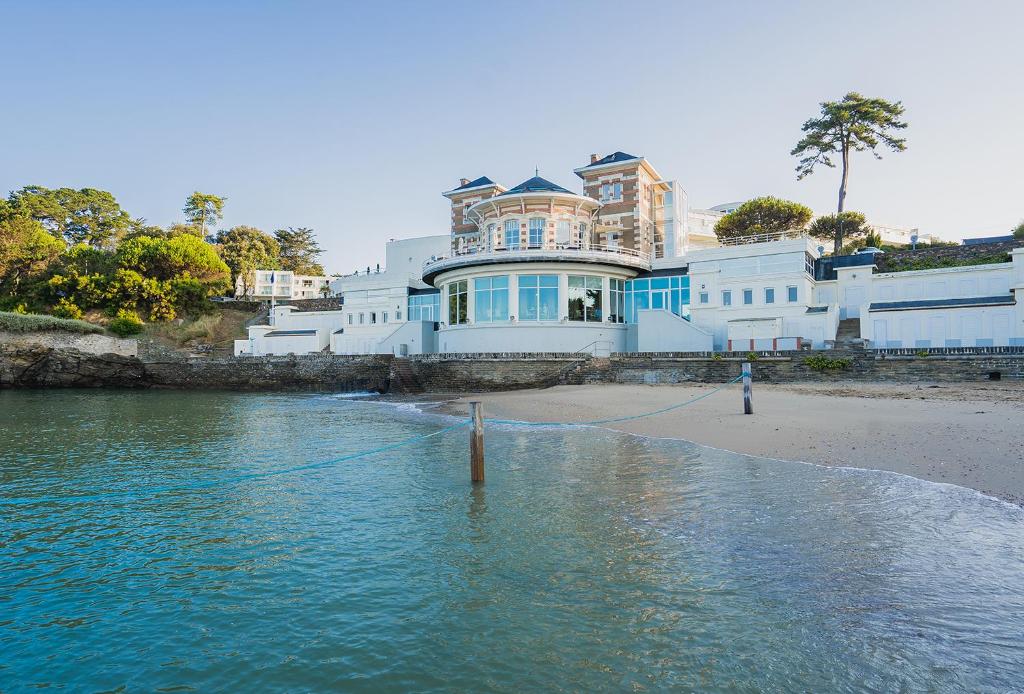 une grande maison sur la plage au bord de l'eau dans l'établissement Alliance Pornic Hôtel Thalasso & Spa, à Pornic