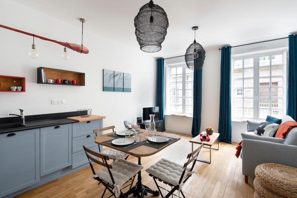 een keuken en een woonkamer met een tafel en stoelen bij Le Code 0 by Cocoonr in Saint-Malo