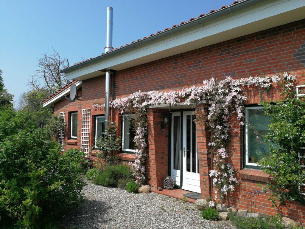 una casa de ladrillo rojo con flores. en Ferienhaus EXTRAZEIT_URLAUB, en Hasselberg