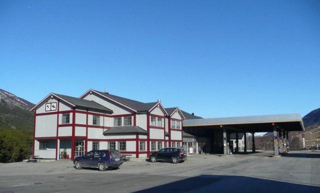 a large building with two cars parked in a parking lot at Dovre Motell in Dovre