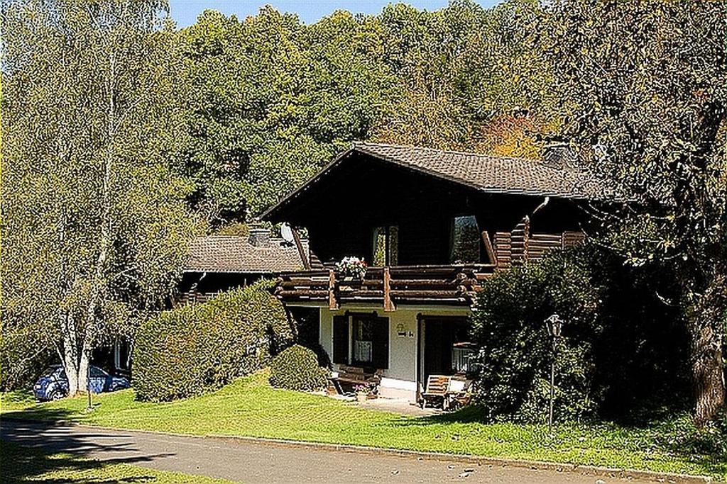 una casa de madera con porche y entrada en Haus 2 - Typ C (kombiniert), en Schönecken