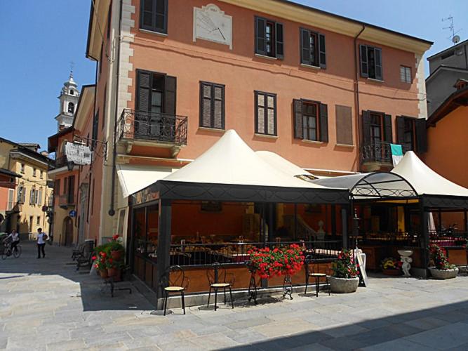 un edificio con mesas y sillas frente a un edificio en Albergo Ristorante Cavallo Bianco, en Dronero