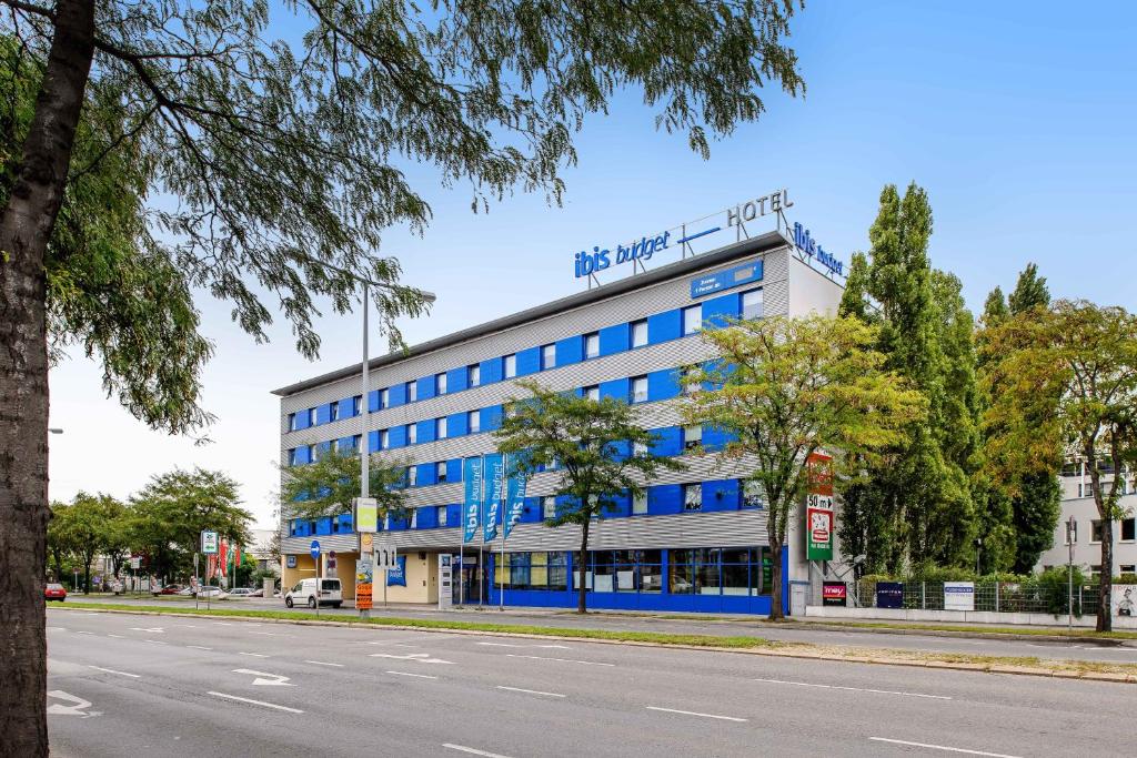 ein Gebäude mit blauen Fenstern auf der Straßenseite in der Unterkunft Ibis budget Wien Sankt Marx in Wien