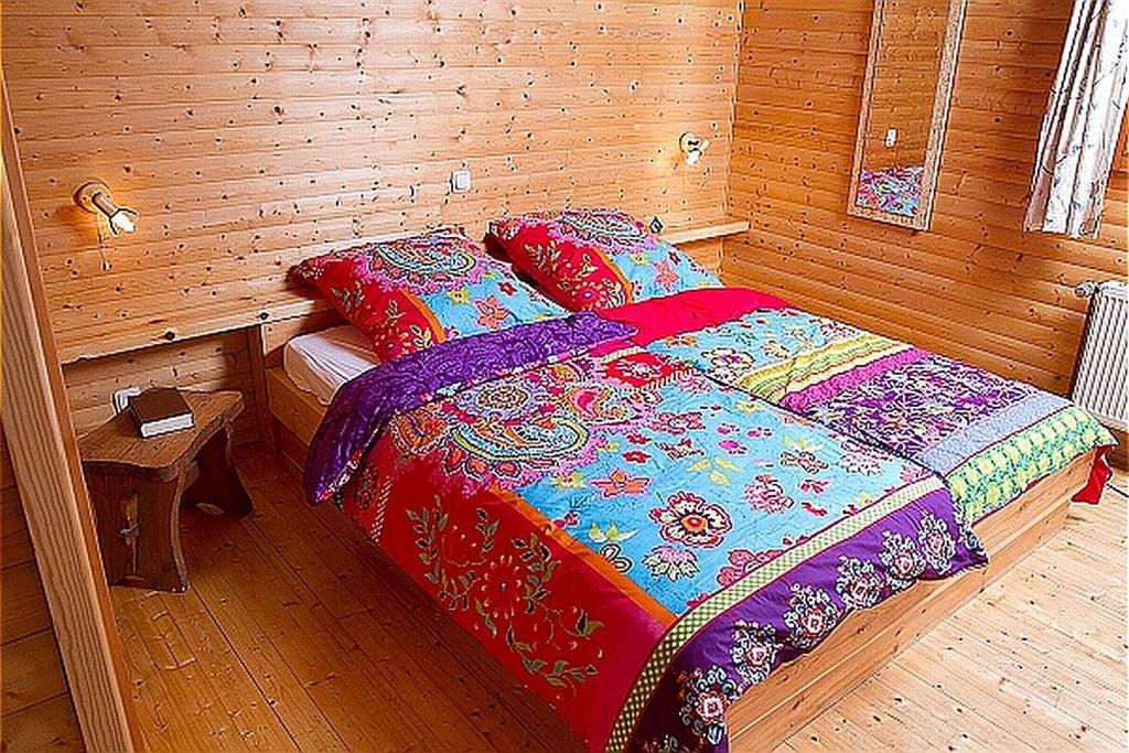 a bedroom with a bed in a wooden room at Haus 1 - Typ C (kombiniert) in Schönecken