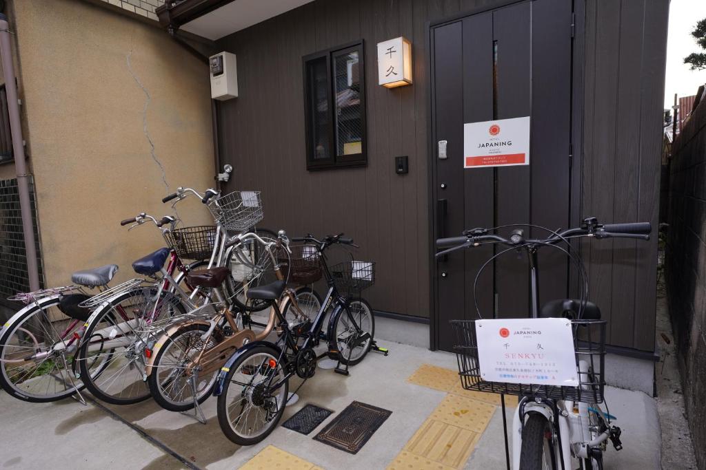 eine Gruppe von Fahrrädern, die außerhalb eines Gebäudes geparkt werden in der Unterkunft JAPANING Senkyu in Kyoto