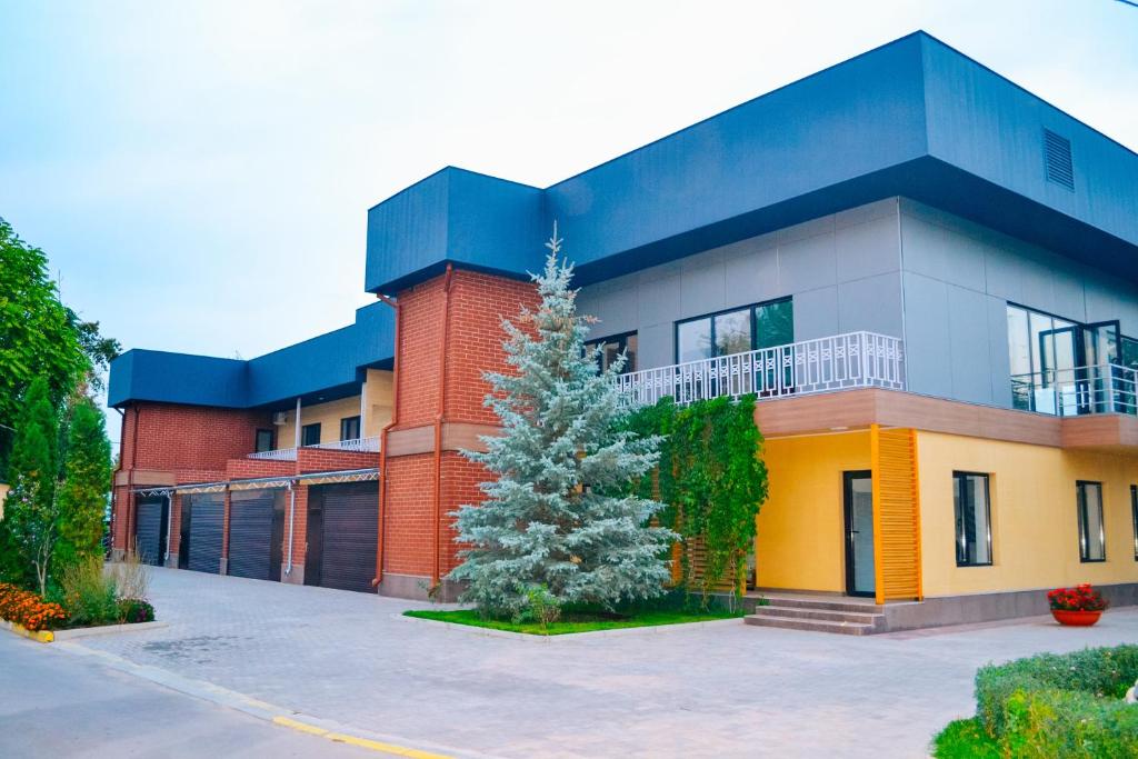 a building with a christmas tree in front of it at Gоlden Dragon Villa Hotel in Bishkek