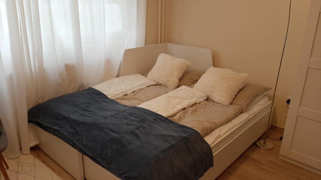 una cama con almohadas en una habitación en MHC Stúdió, en Kaposvár