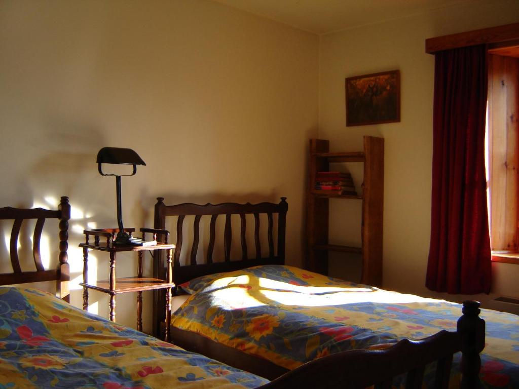 a bedroom with two beds and a lamp and a window at Maurenne in Hastière-Lavaux