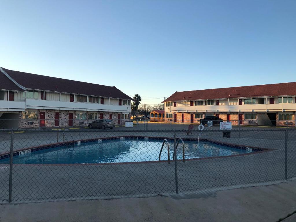 an empty swimming pool in front of some buildings at Royal Inn in Port Lavaca