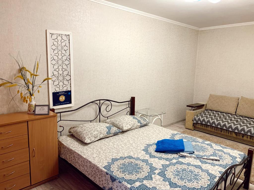ザポリージャにあるApartment - 4А Zaporizka Streetのベッドルーム1室(ベッド1台、ドレッサー、青いバッグ付)
