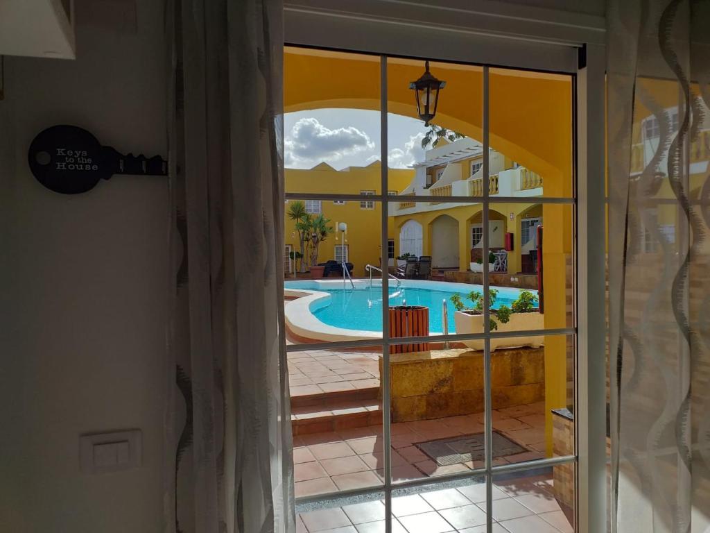 a view of a swimming pool through a glass door at Dream House in Caleta De Fuste