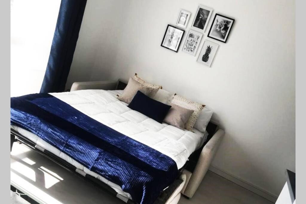 un lit dans une chambre avec des tableaux sur le mur dans l'établissement Tout en Élégance - Pont Rousseau (Nantes), à Rezé