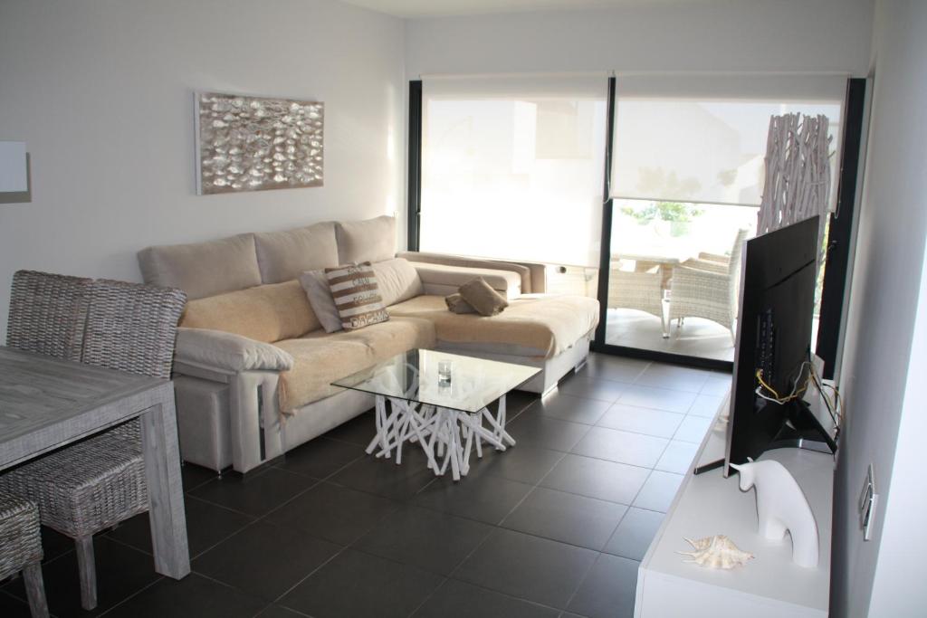 Una sala de estar con un sofá y un televisor. en Casa Skadi, en Villaverde