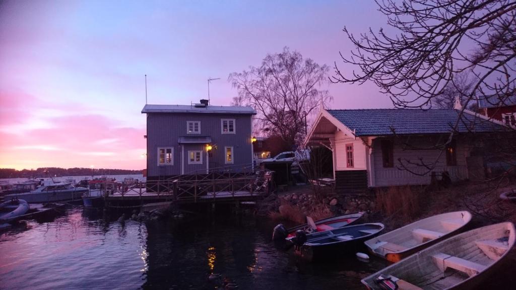una casa en un muelle con barcos en el agua en Vandrarhemmet Lotsen, en Dalarö