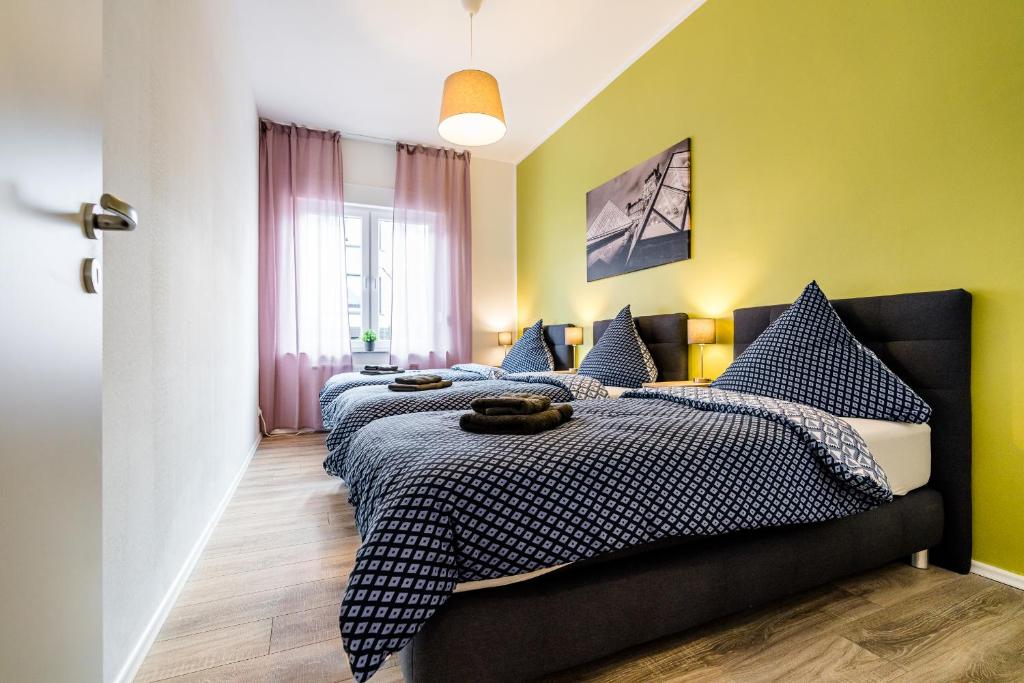 1 Schlafzimmer mit 2 Betten mit blauen und gelben Wänden in der Unterkunft Comodo Apartments Solingen in Solingen