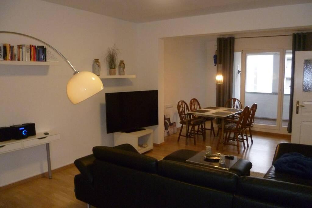 a living room with a couch and a table and a television at Villa Greve - Maisonette Suite in Bad Salzuflen