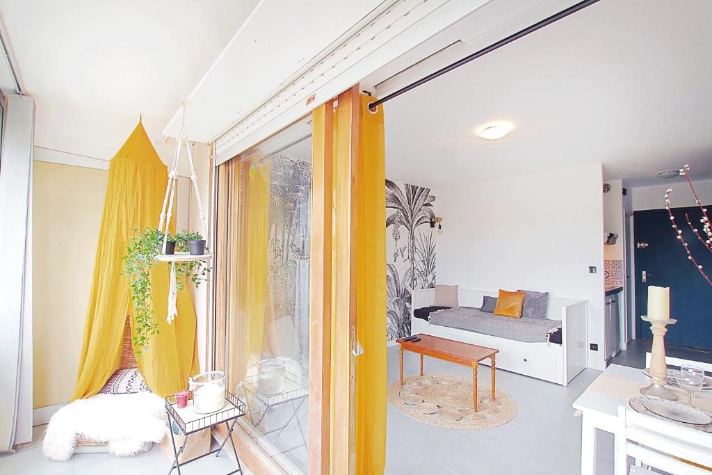 a living room with yellow curtains and a bedroom at Appartement Coup de Coeur avec Parking et Piscine - 131 in Canet-en-Roussillon
