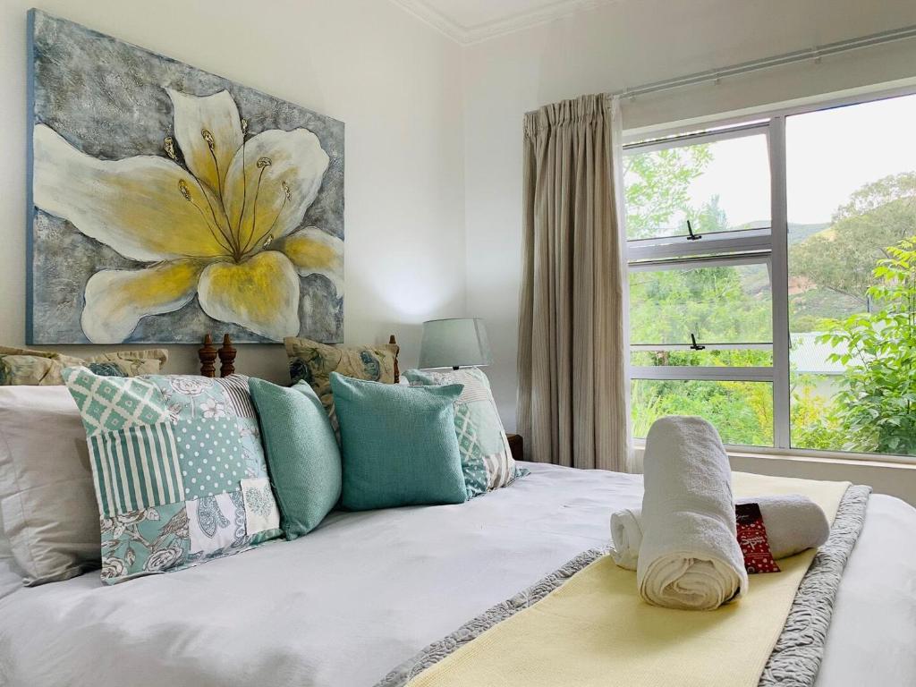 una camera da letto con un letto e un grande dipinto di fiori sul muro di Habitat a Clarens