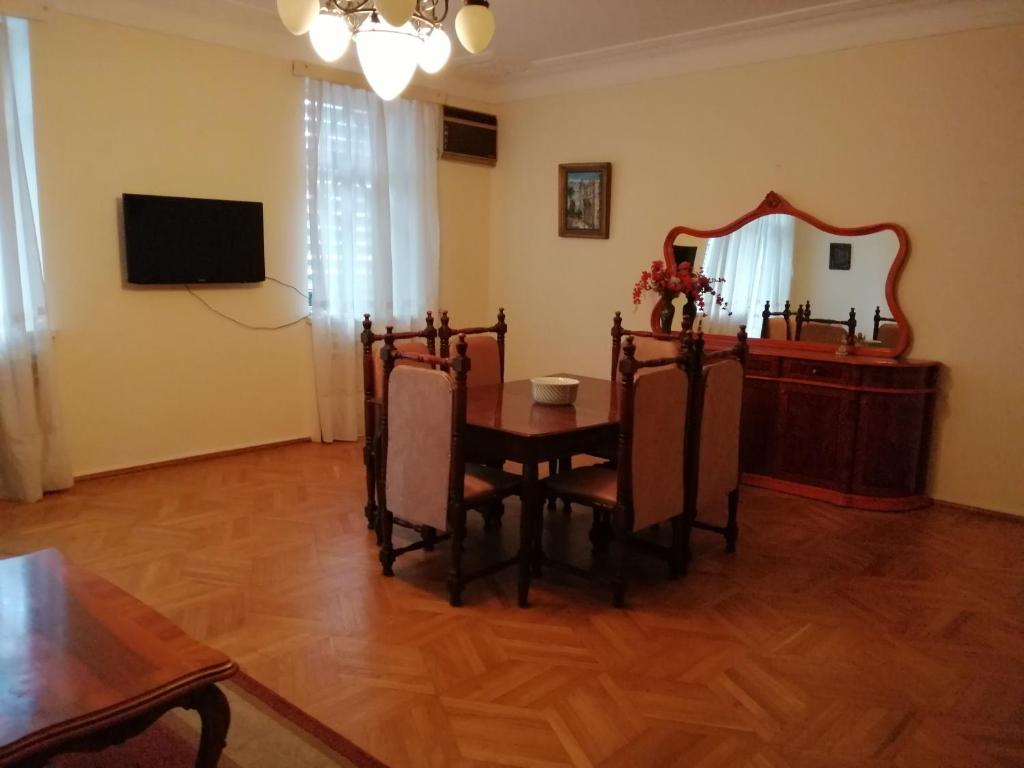 uma sala de estar com uma mesa e um espelho em Apartment on Rustaveli 41 em Batumi
