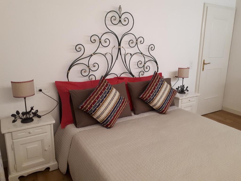 ein Schlafzimmer mit einem großen Bett mit roten Kissen in der Unterkunft Il Borghetto in Chiavenna