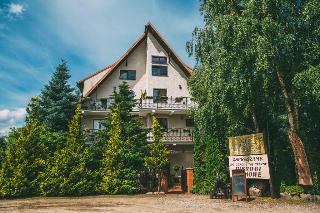ein großes Haus mit einem Schild davor in der Unterkunft Dom wczasowy HEEP in Białogóra