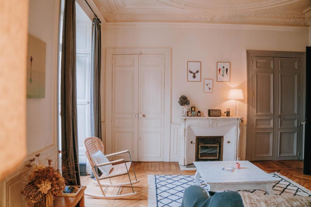 uma sala de estar com uma mesa e uma lareira em Chez Angèle em Rennes