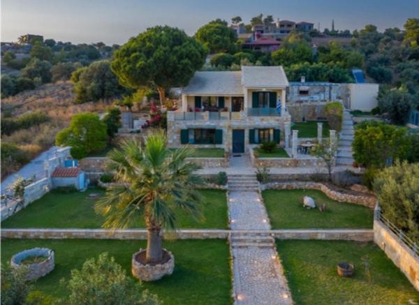 an aerial view of a house with a palm tree at Rikas in Porto Heli