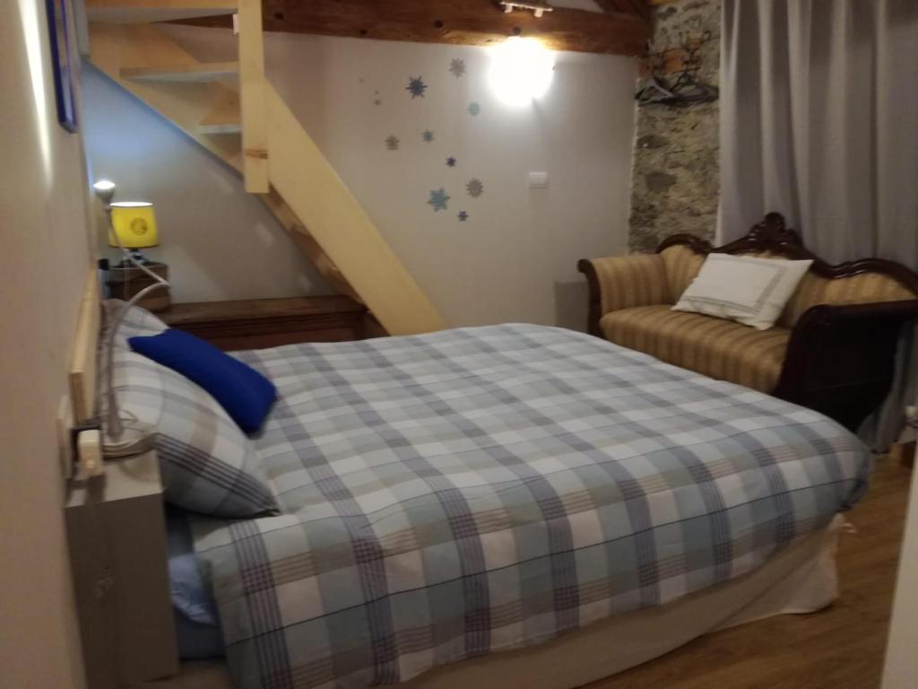 1 dormitorio con cama y escalera en Rifugio Casa Lobietti, en Mollia