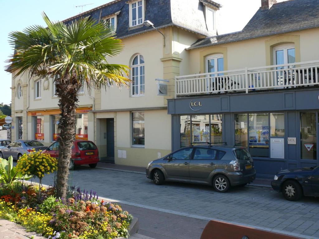 a car parked in front of a building with a palm tree at Résidence du Parad'Ice in Dinard