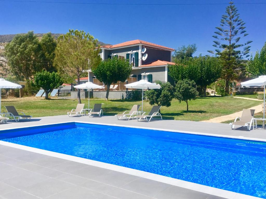 a villa with a swimming pool in front of a house at Alegria Kefalonia in Katelios