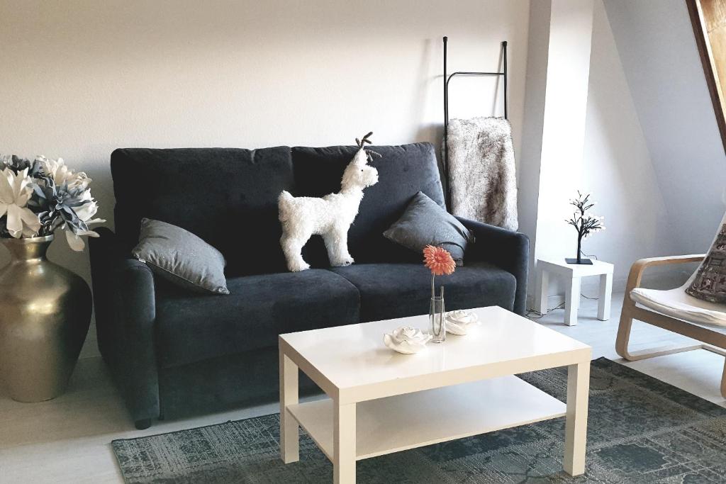 una sala de estar con un sofá azul con un perro blanco. en Baladrias 501, en Formigal