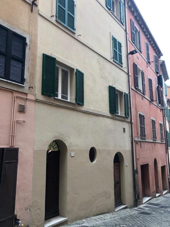 a building with green shutters on it on a street at Appartamento Ali&Dome centralissimo in Ancona
