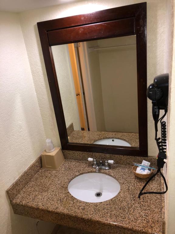 a bathroom counter with a sink and a mirror at Western Inn in Houston