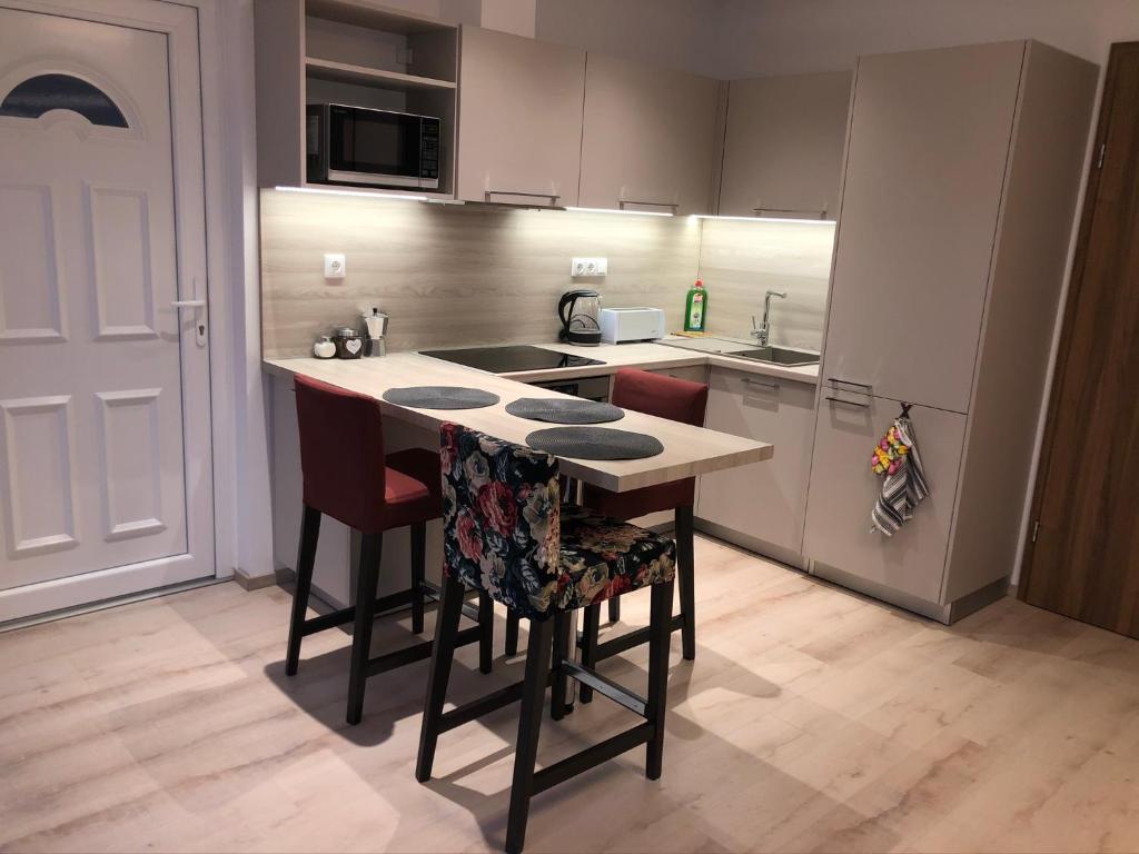 a kitchen with a island with chairs and a counter top at Diamond Apartman in Debrecen