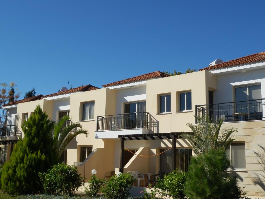 un edificio de apartamentos con balcones y árboles en Byreva Apartments en Pafos