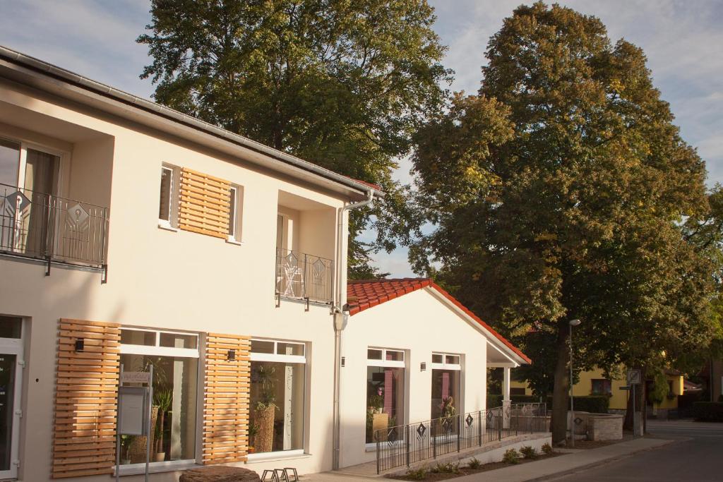 un edificio blanco con ventanas en una calle en Cafe Hehrlich - Cafe, Pension & mehr, en Bad Tennstedt