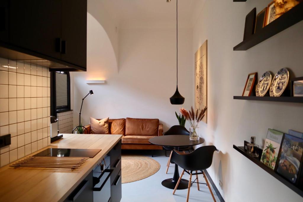 a kitchen and living room with a table and a couch at Overnachten in de oude West-Indiëschool in Enschede